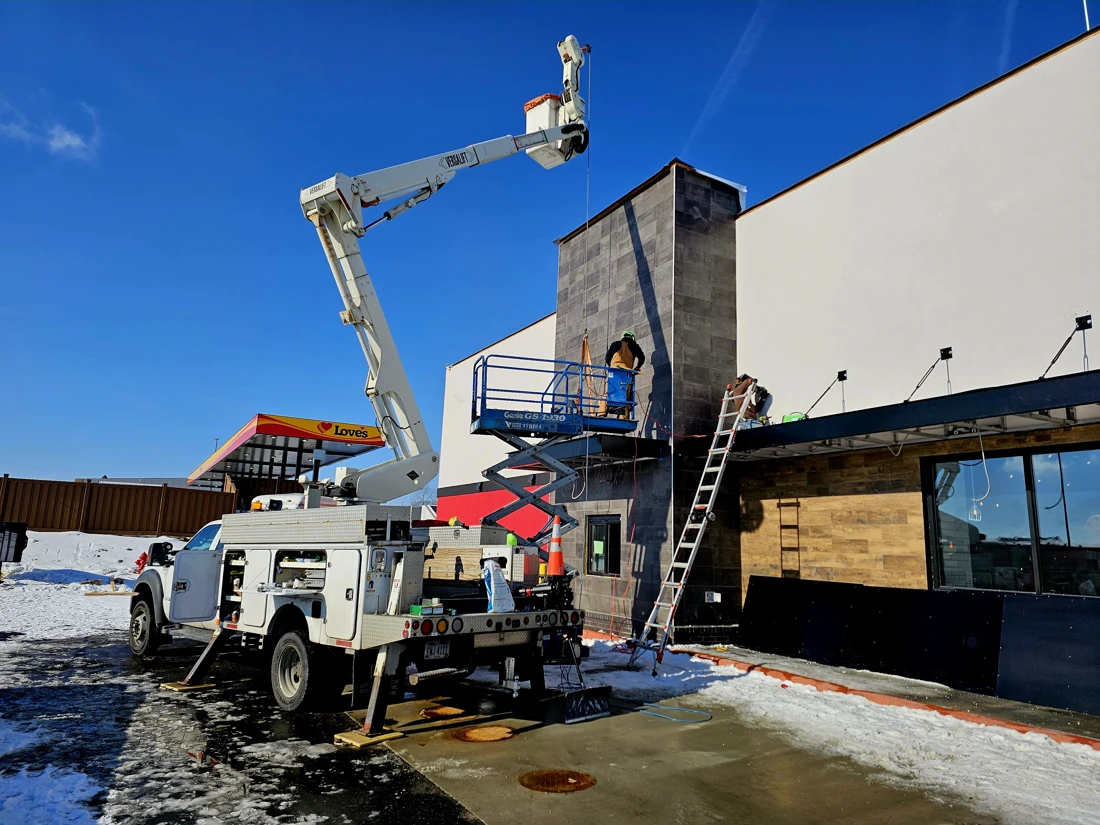 Bucket truck and scissor lift providing access for installation at a commercial building